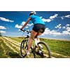 Pretty, young female biker outdoors on her mountain bike (motion blurred image)