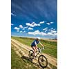 Pretty, young female biker outdoors on her mountain bike (motion blurred image)