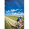 Pretty, young female biker outdoors on her mountain bike (motion blurred image)