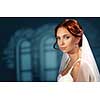 Beautiful bride on a blue background. Wedding dress, veil, red hair. Soft focus.
