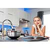 Pretty, young woman in her modern, clean and bright kitchen, uncertain about what to cook (color toned imagey; shallow DOF)