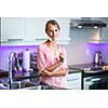 Pretty, young woman posing in her modern kitchen, holding a wooden spoon, ready to cook something delicious (shallow DOF; color toned image)