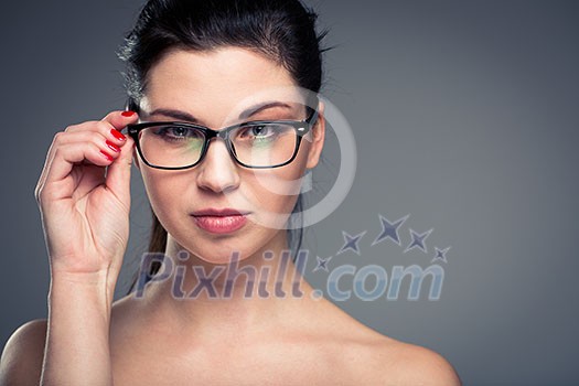 Portrait of a smiling pretty, young woman wearing glasses with copy space - studio shot, color toned Portrait of a smiling pretty, young woman wearing glasses with copy space - studio shot, color toned