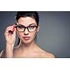 Portrait of a smiling pretty, young woman wearing glasses with copy space - studio shot, color toned