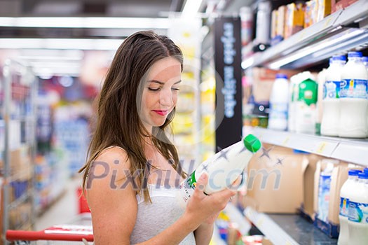 Beautiful young woman shopping in a grocery store/supermarket (color toned image) Beautiful young woman shopping in a grocery store/supermarket (color toned image)