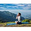 Woman practices pranayama yoga breath control in lotus pose padmasana outdoors in Himalayas in the morning on sunrise. Himachal Pradesh, India
