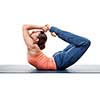 Sporty fit woman practices yoga asana Dhanurasana - bow pose isolated on white