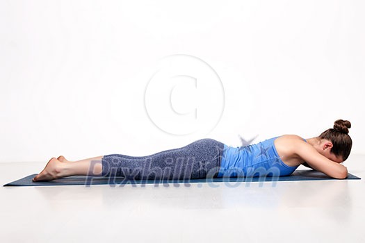 Sporty woman relaxes in yoga asana Makarasana - crocodile pose Sporty woman relaxes in yoga asana Makarasana - crocodile pose