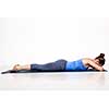 Sporty woman relaxes in yoga asana Makarasana - crocodile pose