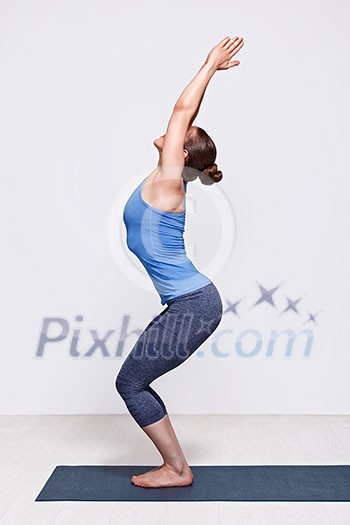 Sporty fit woman doing Surya Namaskar ashtanga vinyasa yoga asana Utkatasana - chair pose Sporty fit woman doing Surya Namaskar ashtanga vinyasa yoga asana Utkatasana - chair pose