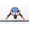 Beautiful sporty fit woman practices Ashtanga Vinyasa yoga asana Prasarita padottanasana B - wide legged forward bend B