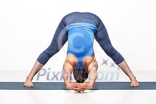 Beautiful sporty fit woman practices Ashtanga Vinyasa yoga asana Prasarita padottanasana C - wide legged forward bend C Beautiful sporty fit woman practices Ashtanga Vinyasa yoga asana Prasarita padottanasana C - wide legged forward bend C