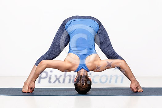 Beautiful sporty fit woman practices Ashtanga Vinyasa yoga asana Prasarita padottanasana D - wide legged forward bend D Beautiful sporty fit woman practices Ashtanga Vinyasa yoga asana Prasarita padottanasana D - wide legged forward bend D
