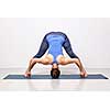 Beautiful sporty fit woman practices Ashtanga Vinyasa yoga asana Prasarita padottanasana D - wide legged forward bend D
