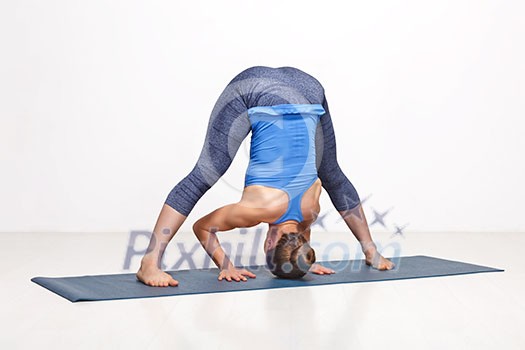 Beautiful sporty fit woman practices Ashtanga Vinyasa yoga asana Prasarita padottanasana B - wide legged forward bend B Beautiful sporty fit woman practices Ashtanga Vinyasa yoga asana Prasarita padottanasana B - wide legged forward bend B