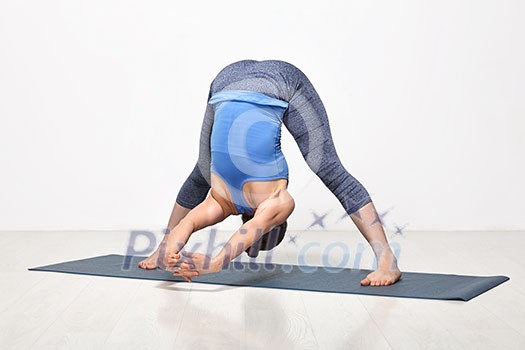 Beautiful sporty fit woman practices Ashtanga Vinyasa yoga asana Prasarita padottanasana C - wide legged forward bend C Beautiful sporty fit woman practices Ashtanga Vinyasa yoga asana Prasarita padottanasana C - wide legged forward bend C