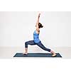 Beautiful sporty fit yogini woman practices yoga asana Virabhadrasana 1 - warrior pose 1