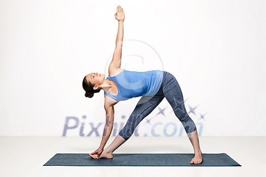 Beautiful sporty fit woman practices Ashtanga Vinyasa yoga asana utthita trikonasana - extended triangle pose Beautiful sporty fit woman practices Ashtanga Vinyasa yoga asana utthita trikonasana - extended triangle pose