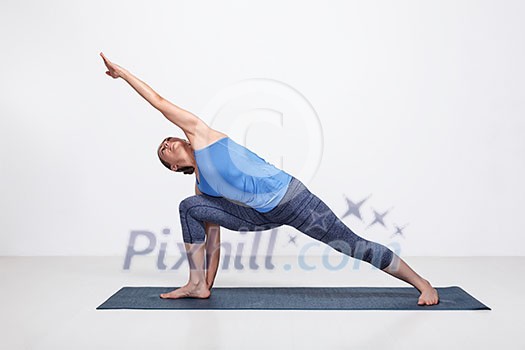 Young fit woman doing Ashtanga Vinyasa Yoga asana Utthita parsvakonasana - extended side angle pose advanced variation Young fit woman doing Ashtanga Vinyasa Yoga asana Utthita parsvakonasana - extended side angle pose advanced variation