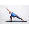 Young fit woman doing Ashtanga Vinyasa Yoga asana Utthita parsvakonasana - extended side angle pose advanced variation