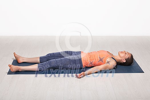 Beautiful sporty fit yogini woman relaxes in yoga asana Savasana - corpse pose in studio Beautiful sporty fit yogini woman relaxes in yoga asana Savasana - corpse pose in studio