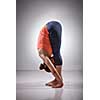 Sporty fit woman practices bending yoga asana Uttanasana - standing forward bend pose