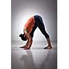 Sporty fit woman stretching in Ashtanga Vinyasa yoga asana Parsvottanasana - intense side stretch pose