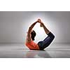 Sporty fit woman practices yoga asana Dhanurasana - bow pose
