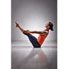 Beautiful sporty fit yogini woman practices yoga asana Paripurna navasana - boat pose