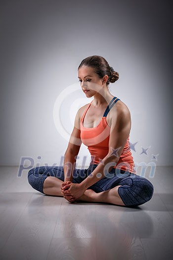 Beautiful sporty fit woman practices yoga asana Baddha konasana - bound angle pose Beautiful sporty fit woman practices yoga asana Baddha konasana - bound angle pose