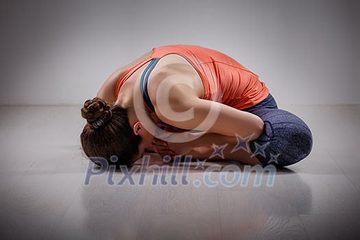 Beautiful sporty fit woman practices yoga asana Baddha konasana - bound angle pose Beautiful sporty fit woman practices yoga asana Baddha konasana - bound angle pose