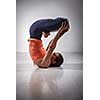 Sporty fit yogini woman practices inverted yoga asana Urdhva padmasana - lifted lotus pose