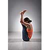 Sporty fit woman practices yoga asana Urdhva mukha paschimottanasana - upward facing intense west stretch