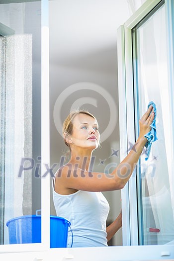 Pretty, young woman doing house work - washing windows Pretty, young woman doing house work - washing windows