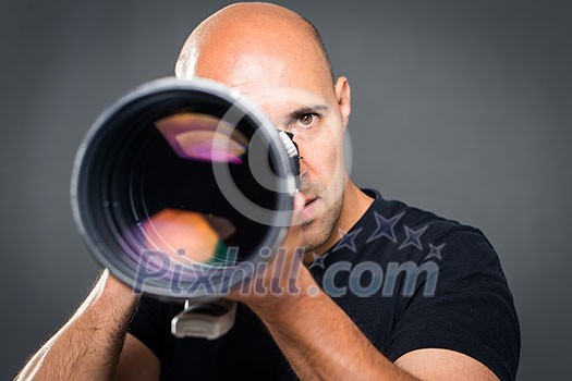 Young, pro male photographer in his studio during a photo shoot (color toned image; shallow DOF) Young, pro male photographer in his studio during a photo shoot (color toned image; shallow DOF)