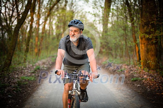 Senior man on his mountain bike outdoors (shallow DOF; color toned image) Senior man on his mountain bike outdoors (shallow DOF; color toned image)