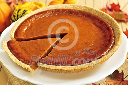 Whole pumpkin pie with a slice cut out Whole pumpkin pie with a slice cut out