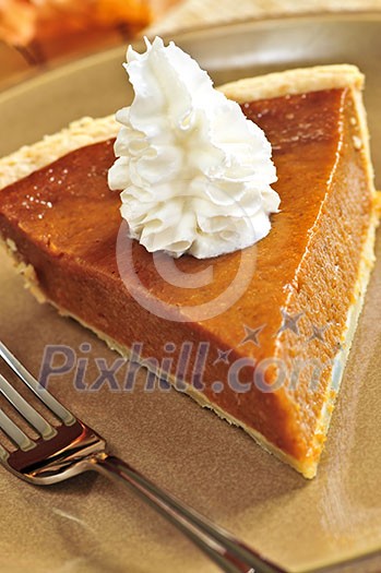 Slice of pumpkin pie with fresh whipped cream Slice of pumpkin pie with fresh whipped cream
