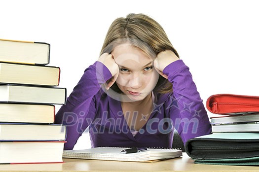 Unhappy teenage girl studying at the desk Unhappy teenage girl studying at the desk