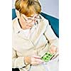 Elderly woman holding pill box with medication