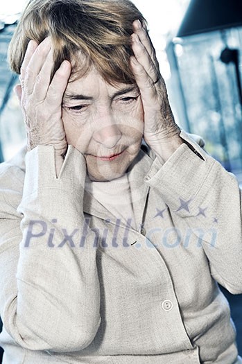 Senior woman holding head in her hands Senior woman holding head in her hands