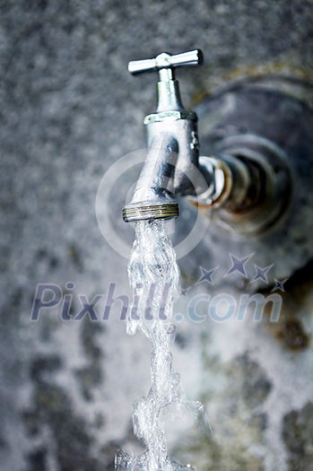 Closeup of water running from outdoor wall faucet Closeup of water running from outdoor wall faucet