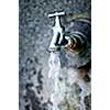 Closeup of water running from outdoor wall faucet