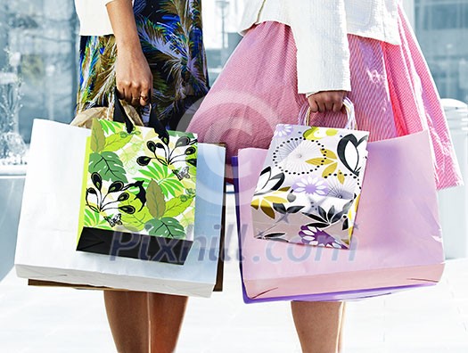 Two young girl friends holding shopping bags at mall Two young girl friends holding shopping bags at mall