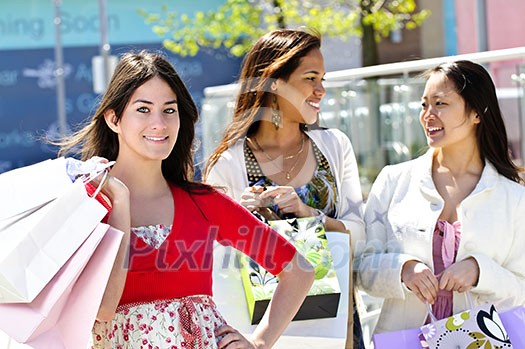 Three young girl friends holding shopping bags at mall Three young girl friends holding shopping bags at mall
