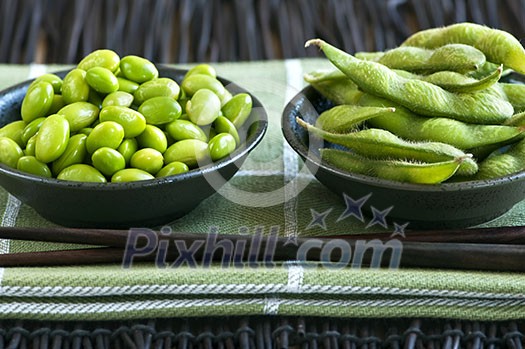 Edamame soy beans shelled and with pods in bowls Edamame soy beans shelled and with pods in bowls