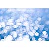 Out of focus bokeh background of blue water with sun reflections. Can be used as Christmas or winter backdrop.