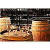 Row of wine glasses on barrel in winery cellar