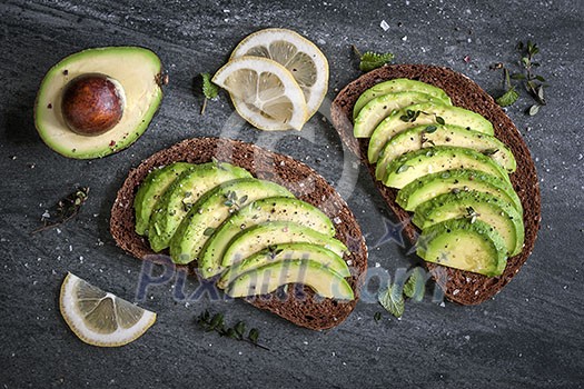 Avocado sandwich on dark rye bread made with fresh sliced avocados from above Avocado sandwich on dark rye bread made with fresh sliced avocados from above