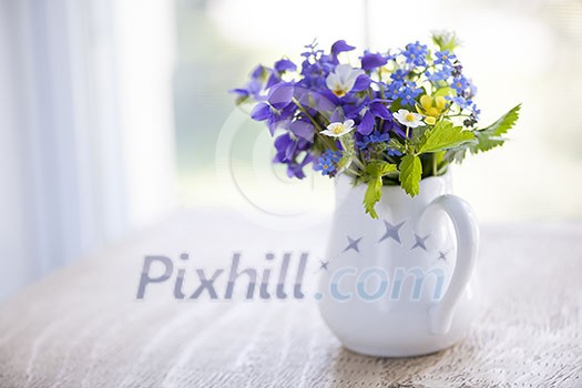 Bouquet of wild flowers in white vase on rustic wooden table near window with copy space, natural light Bouquet of wild flowers in white vase on rustic wooden table near window with copy space, natural light